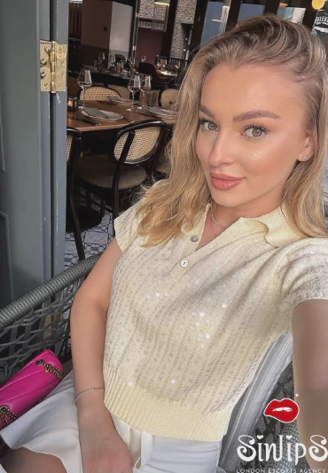 Adela, blonde escort in restaurant selfie