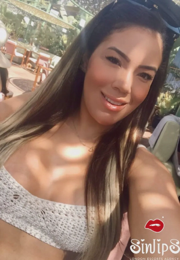 Janine, Brazilian bum escort in a white top selfie